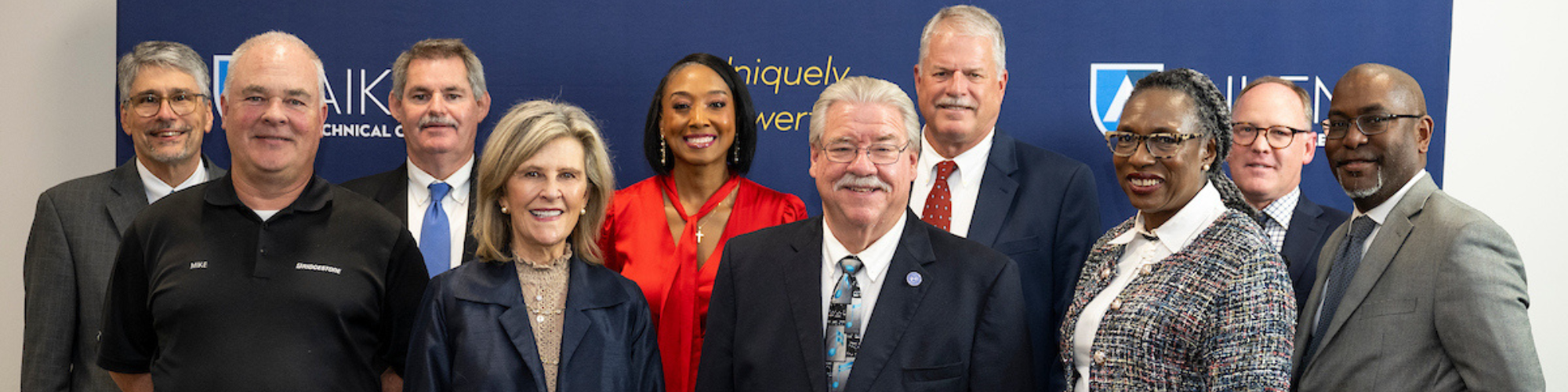 Group of commissioners standing in front of navy backdrop