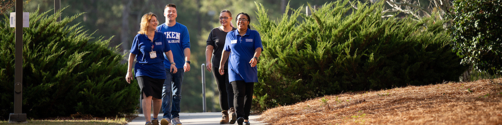 Four students walking outside on campus
