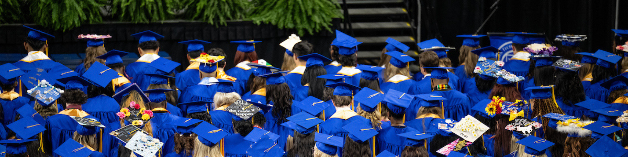 Aerial shot of graduates in audience with the top of their caps visible