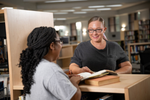 Two students talking in the library