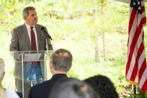 Joe Lewis standing at podium speaking to crowd
