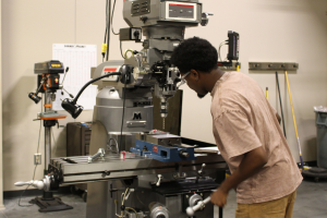 Student working with machine tool equipment